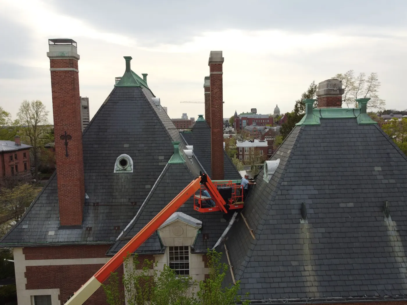 Slate roof repair on a historic New England home with lift equipment