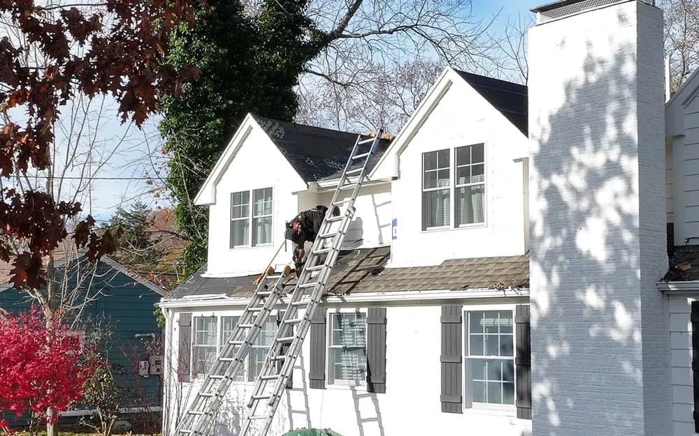 Roof inspector examining shingles on residential roof