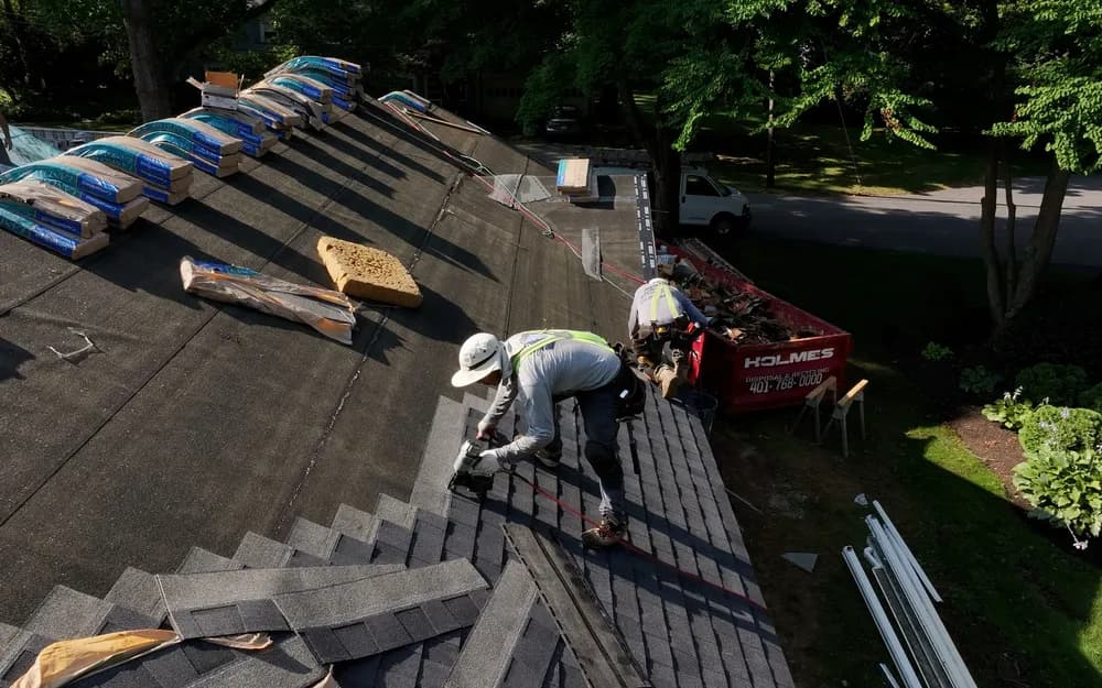 Roofing crew installing shingles on residential home
